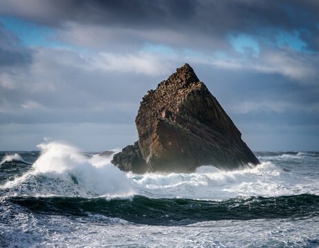 waves crashing against isolated rock in rough sea