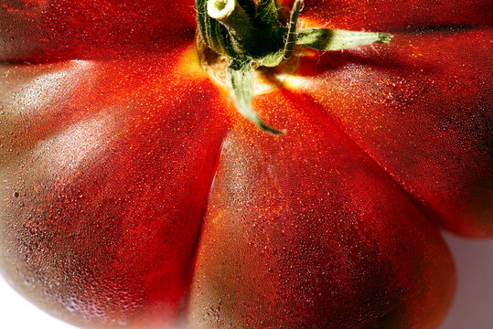 Close-up of fresh heirloom tomato with water droplets.