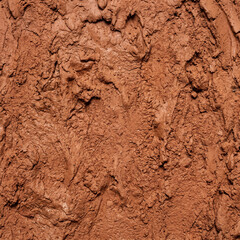 Fototapeta premium Closeup of rough textured red clay surface showcasing natural earthy tones and uneven patterns