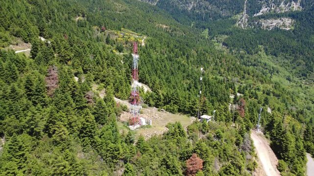 Aerial shot of cellular antenna and substation on remote mountain slope