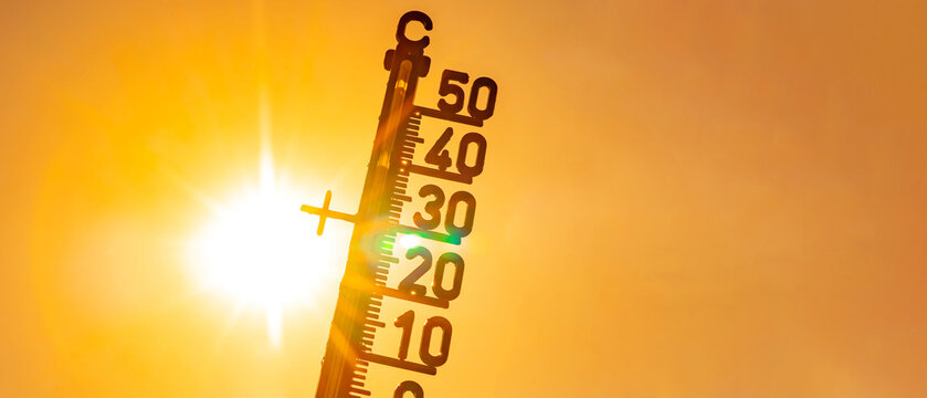 Hot weather - Heat wave / Summer heat background - Thermometer yellow orange sky and sun rays