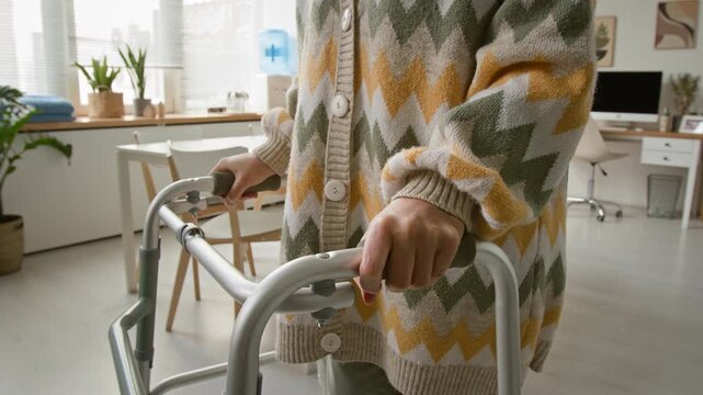 Unrecognizable senior woman holding walker frame in nursing home. For senior care services and medical equipment marketing