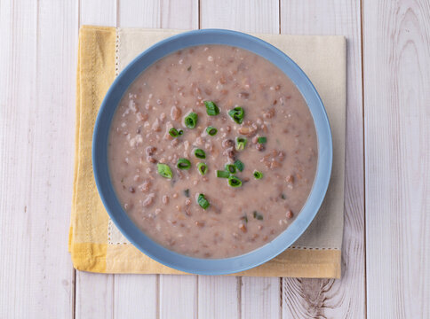 Brown bean soup in a bowl over wooden table
