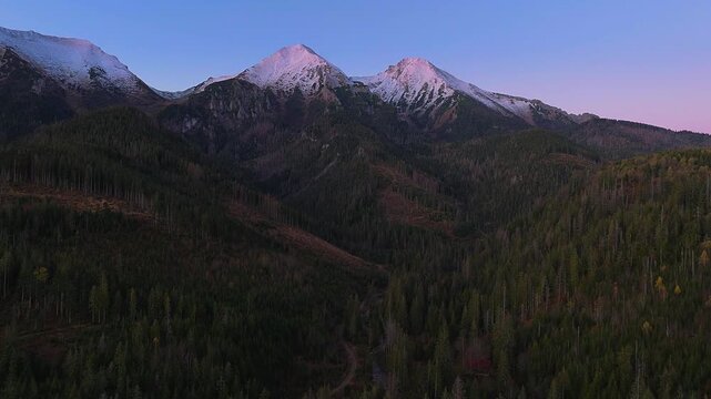 High Tatras, Slovakia - 4K flying towards the High Tatras mountains on an autumn morning at sunrise with blue sky and pink Tatras peaks