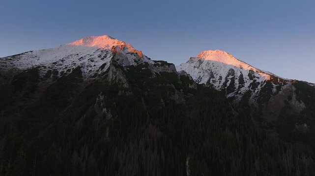 High Tatras, Slovakia - 4K flying towards the High Tatras mountains on an autumn morning at sunrise with blue sky and pink Tatras peaks