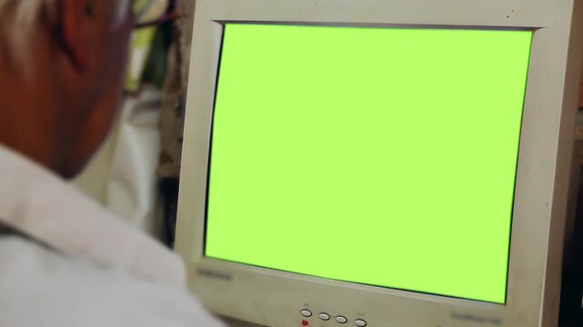 Over The Shoulder View Of Blurred Man Looking At Vintage Monitor Green Screen - 4K