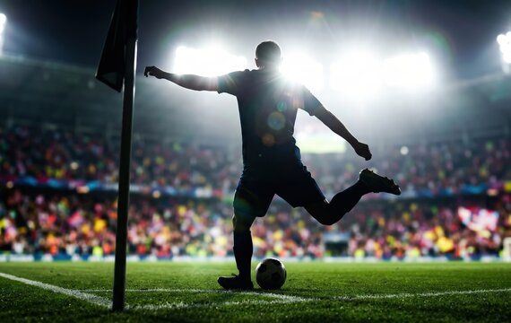 Soccer player taking a corner kick during a nighttime match