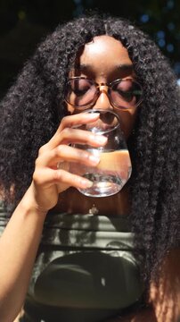 Young woman drinking water in a cafe closeup