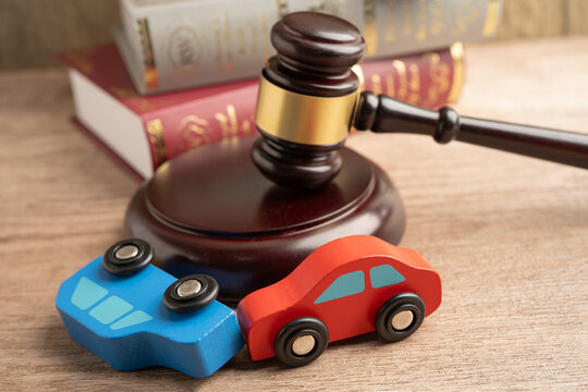 Car accident lawsuit and insurance, Judge hammer with car model.