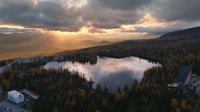 Strbske Lake, Slovakia - 4K Flying above Strbske Lake (Strbske Pleso) on a sunny autumn afternoon at sunset with autumn foliage and warm sunlight and clouds