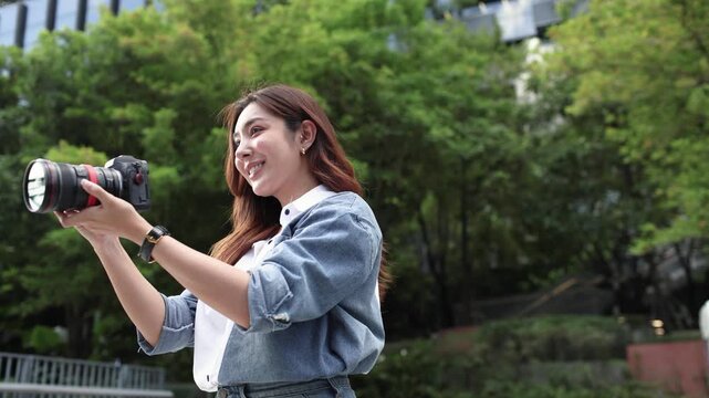 Female Photographer Adjusting Camera Before Taking Photos Outdoors
