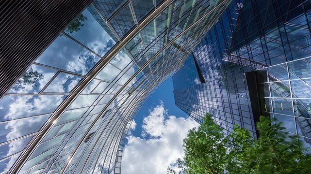 Low angle wide shot time-lapse of downtown glass skyscrapers, financial district high-rise office buildings, modern city architecture, blue sky and white clouds