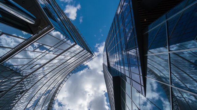 Downtown city center street low angle time-lapse of tall glass skyscrapers and modern office buildings, sunny weather with white clouds