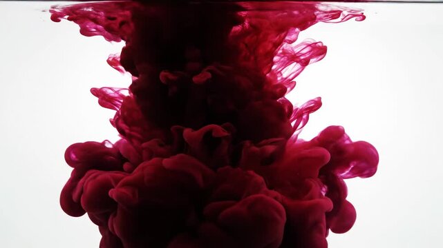 Color mixing in water with red and black ink at a studio setting