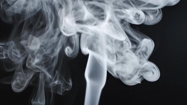 Smoke rises above a dark surface and creates swirling patterns in the air