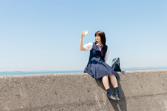 スマートフォンを自撮りする女子高校生