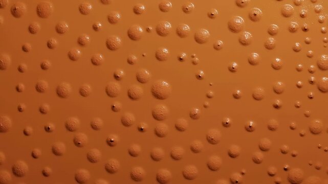 Close-up panoramic view of glossy raised orange bumps on matte surface with soft directional highlights, rhythmic grid repetition, smooth finish, and modern abstract texture