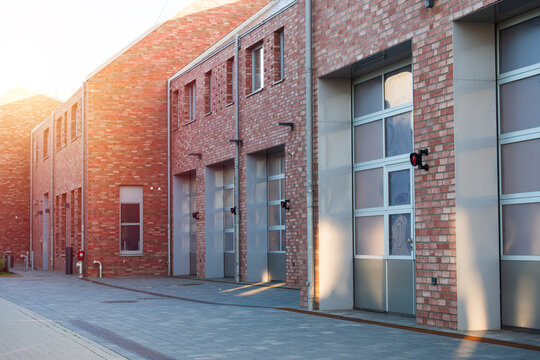 Red Brick Building Facade with Row of Industrial Garage Doors, The Concept of Modern Architecture