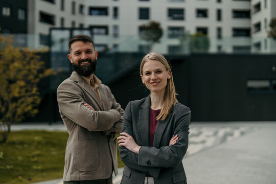 Diverse business professionals standing with folded arms outdoors