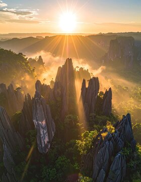Dramatic sunrise illuminates jagged limestone peaks shrouded in mist.