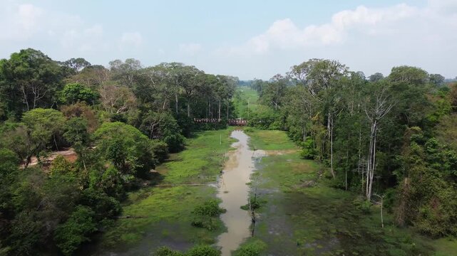 Drone flying backwards revealing the neak pean, a buddhist temple in the angkor complex in cambodia
