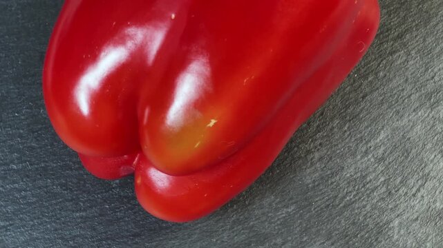 Fresh red bell pepper on a black slate flat plate