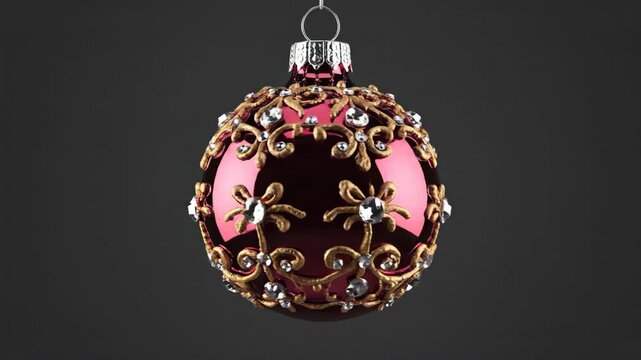 elegant burgundy christmas bauble with gold filigree and sparkling jewels hanging on dark background. winter holiday decoration. new year concept. invitation, greeting card with copyspace