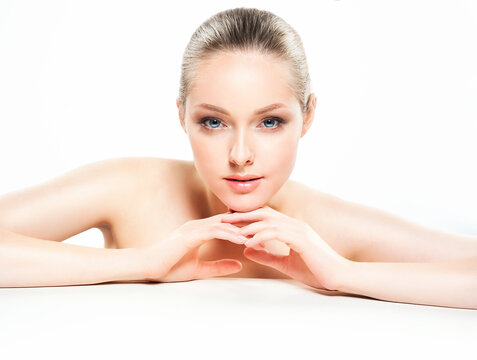 Beautiful Young Woman with Clean Fresh Skin touch own face . Facial treatment . Cosmetology , beauty and spa .
