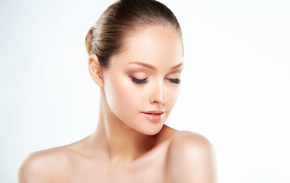 Beautiful Young Woman with Clean Fresh Skin touch own face . Facial treatment . Cosmetology , beauty and spa .
