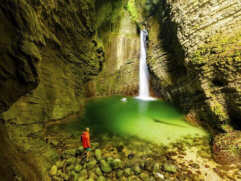 Person in front of Kozjak waterfall, Kobarid, Soca valley, Triglav National Park, Slovenia
