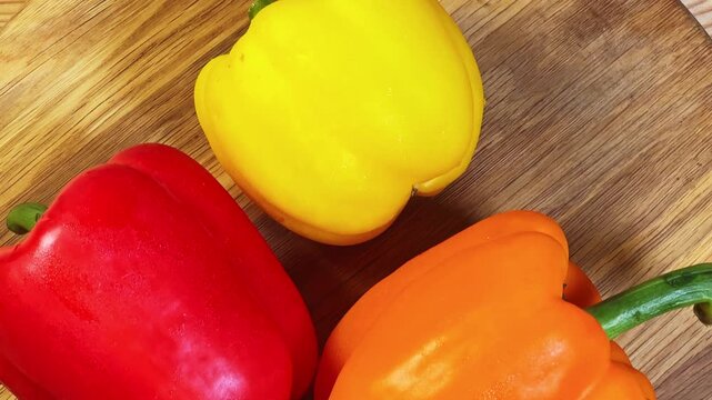 Whole bell peppers different colors on cutting board, top view