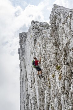 Young man climbing a vertical rock face without a rope, rocky mountains and scree, near Hochkalter, Berchtesgadener Alpen, Berchtesgadener Land, Upper Bavaria, Bavaria, Germany