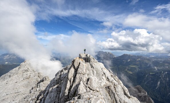 Mountaineer on the rocky summit of the Watzmann Mittelspitze, Watzmann crossing, view of mountain panorama, Berchtesgaden National Park, Berchtesgaden Alps, Bavaria, Germany