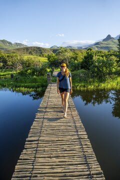 Young tourist on a jetty by a lake, Royal Natal National Park, Drakensberg Mountains south, Kwa Zulu Natal, South Africa