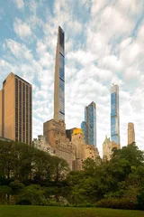The iconic New York City skyline viewed from Central Park featuring the tall skinny skyscrapers of Billionaires Row standing beyond a peaceful pond. © Jose Luis Stephens