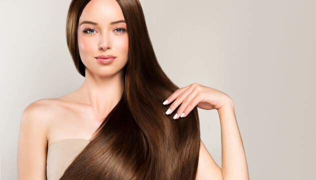 Beautiful model girl with shiny brown and straight long hair . Keratin straightening . Treatment, care and spa procedures. Smooth hairstyle.
