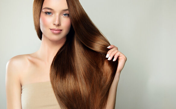 Beautiful model girl with shiny brown and straight long hair . Keratin straightening . Treatment, care and spa procedures. Smooth hairstyle.
