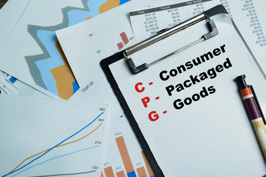 Concept of CPG - Consumer Packaged Goods write on clipboard isolated on Wooden Table.