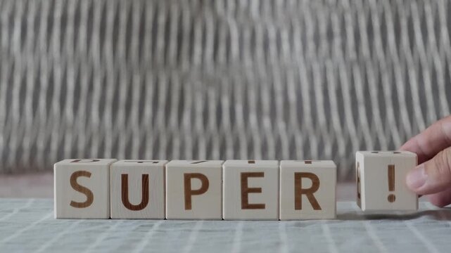 motivational word super !, laying out  by hand from letters on wooden cubes, slow motion
