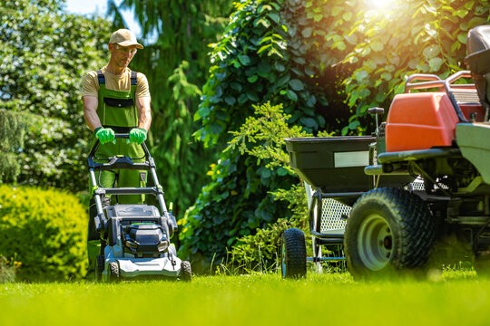 Man mowing the lawn in daytime at a residential garden layout