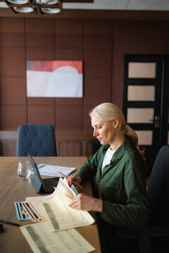 A woman studies documents sitting at her desk
