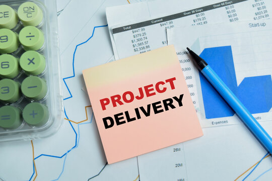 Concept of project delivery write on sticky notes isolated on Wooden Table.