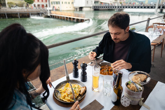 Young couple dining at an outdoor riverfront restaurant