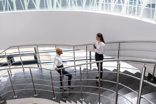 Multiracial businesswomen talking on staircase
