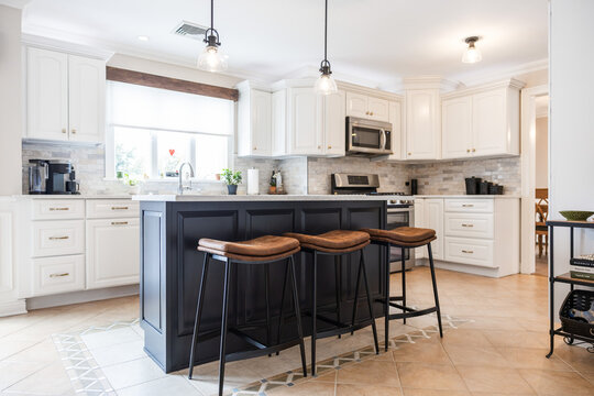 Modern White Kitchen with Black Island and Leather Bar Stools