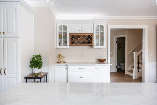 Bright White Kitchen with Built-in Wine Rack and Marble Countertops