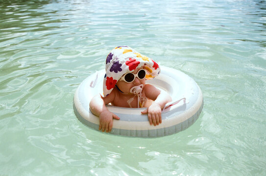 A toddler enjoys time spent in the ocean with an inflatable ring.