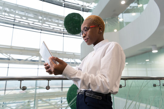 African American woman analyst browsing tablet near railing
