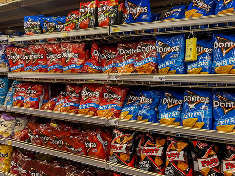 Texas, USA - April 15, 2024: Snack aisle stocked with various flavors and party sizes of Doritos tortilla chips in a supermarket. Texas, USA. 