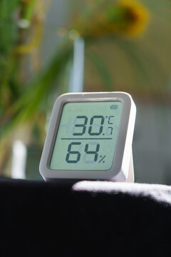 Digital thermometer showing 30 degrees Celsius indoors during a summer heat wave